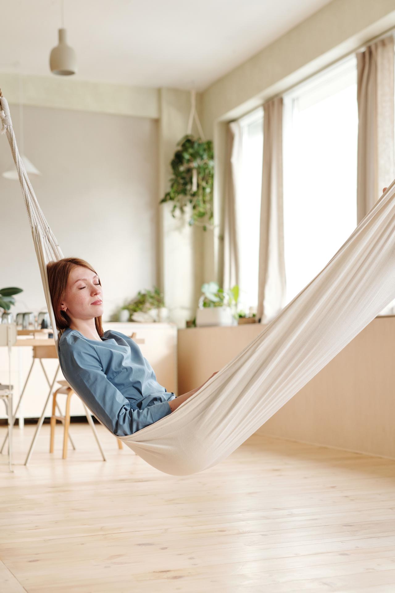 Femme détendue chez elle pour une séance de soin énergétique à distance.